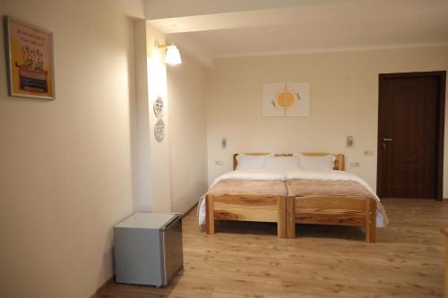 a bedroom with a bed and a wooden floor at h’Olarooms N3 in Tʼianetʼi