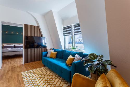 a blue couch in a living room with a blue at FeelgooD Apartments COZY Leipzig CityCenter mit TG-Stellplatz in Leipzig