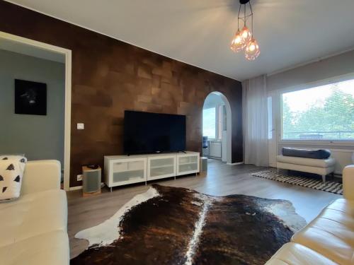 sala de estar con sofá y TV en Freshly renovated apartment, perfect for couple, en Kerava