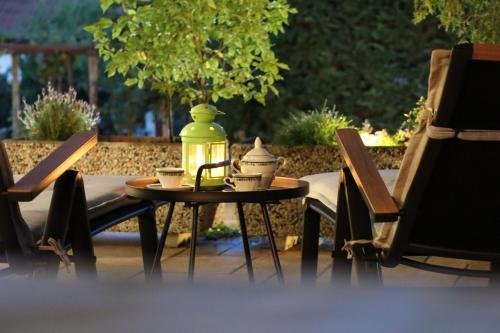 Una mesa con dos sillas y una botella. en Garden Villa en Štanjel