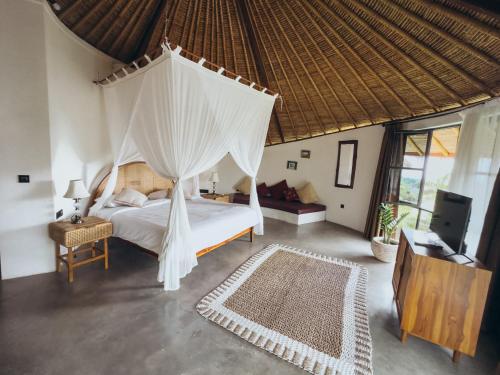a bedroom with a bed with a mosquito net at Hillstone U Villa in Uluwatu