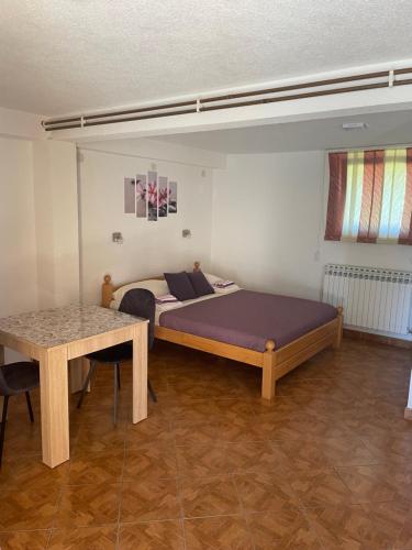 a bedroom with a bed and a table at Rooms Marijanović Plitvice in Vrelo Koreničko