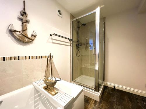een badkamer met een douche en een standbeeld van een boot op een tafel bij Beautiful 1-Bedroom Apartment with Pool - Great Ferry offers in Shanklin