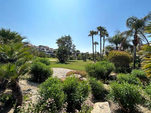 un jardin avec des plantes et des palmiers sur une plage dans l'établissement Ático junto al Mar,Acceso directo a la playa,Jardines de Nuevo Vera,WIFI, à Vera