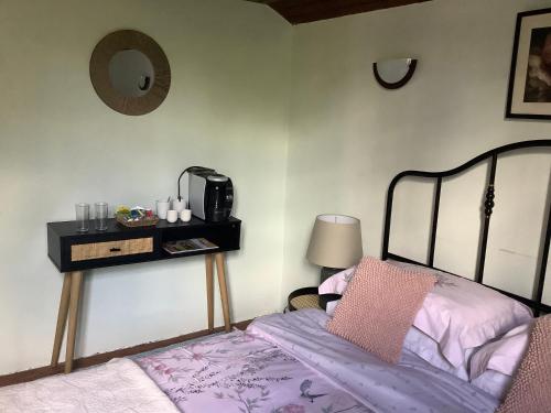 a bedroom with a bed and a table with a mirror at No. 5 Plaisance - Room 2 in Plaisance