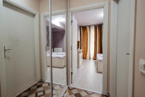 ein Badezimmer mit einer Glastür, die zu einem Schlafzimmer führt. in der Unterkunft Luxury Radox Apartment Airport Bucharest 2 in Otopeni