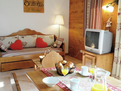a living room with a couch and a tv at Attractive apartment with a balcony in Le Grand Massif in Samoëns