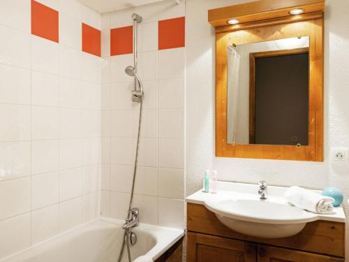 a bathroom with a sink and a tub and a mirror at Attractive apartment with a balcony in Le Grand Massif in Samoëns