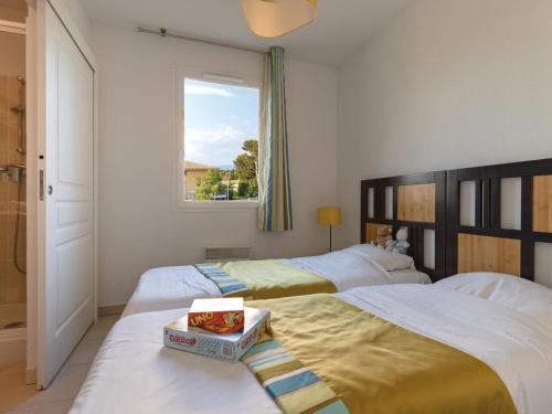 een slaapkamer met 2 bedden en een raam bij Nice apartment with terrace and sea view in Six-Fours-Les-Plages in Six-Fours-les-Plages