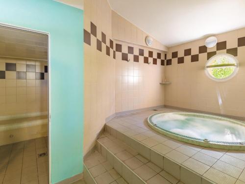 La salle de bains est pourvue d'une baignoire jacuzzi et d'une fenêtre. dans l'établissement Apartment in Six-Fours with Sea View, à Six-Fours-les-Plages