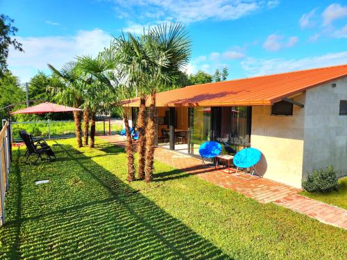 a house with palm trees in front of it at House&Yard Hellen 150m to beach in Ureki