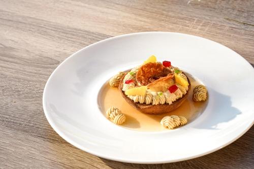 a white plate with a sandwich on a table at Maison Jenny Hotel Restaurant & Spa in Hagenthal-le-Bas