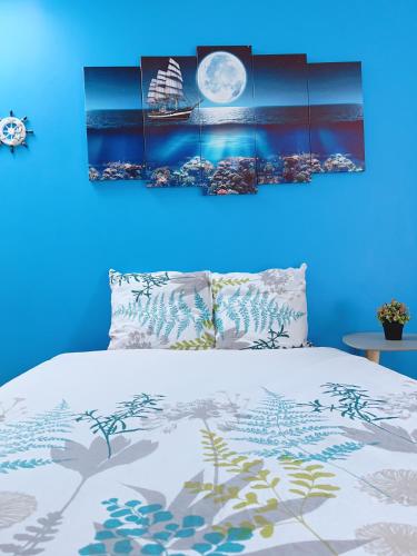 - une chambre bleue dotée d'un lit avec un mur bleu dans l'établissement Le MonMon des Minimes, à La Rochelle