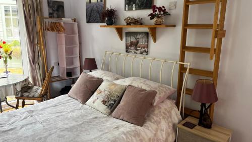 Un dormitorio con una cama con almohadas. en Mole End, en Withypool