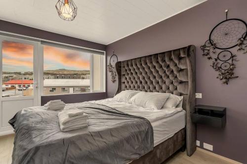 a bedroom with a large bed and a window at Venture Vacation-Family Friendly Retreat-HOT TUB in Mosfellsbær