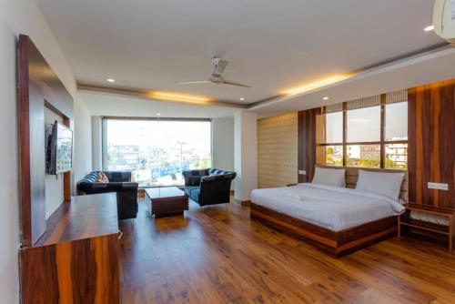 Hotel DOON في دهرادون: غرفة نوم مع سرير وغرفة معيشة