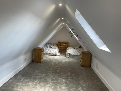a attic bedroom with two beds and a roof at The Greig 1A in Wadhurst