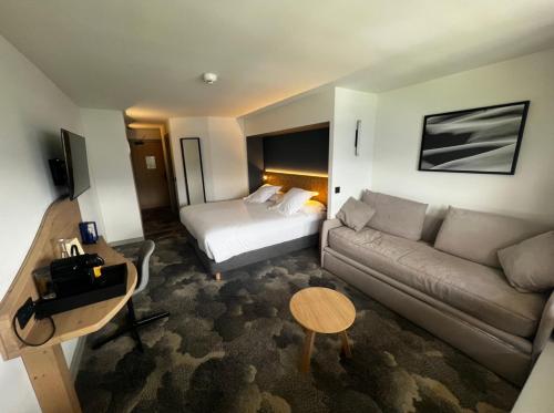 a hotel room with a couch and a bed at La Cachette, Friendly Hotel & Spa in Arc 1600