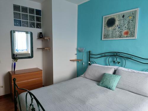 1 dormitorio con 1 cama con pared azul en Guardando le Mainarde, 