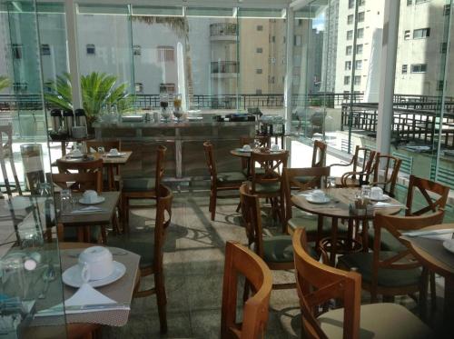 a restaurant with tables and chairs in a building at Upper Hotel in São Paulo