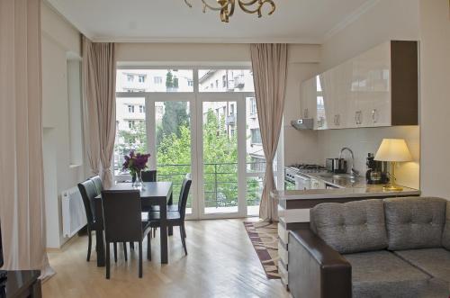 cocina y comedor con mesa, cocina y sala de estar en TiflisLux Apartment en Tiflis