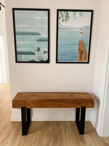 a wooden bench in a room with two pictures on the wall at Lake House Borowe in Borowe