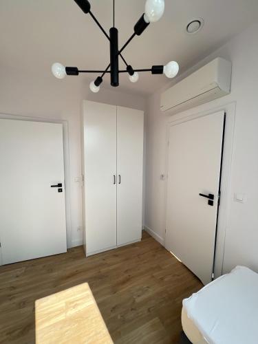 a bedroom with two doors and a bed and a chandelier at Lake House Borowe in Borowe