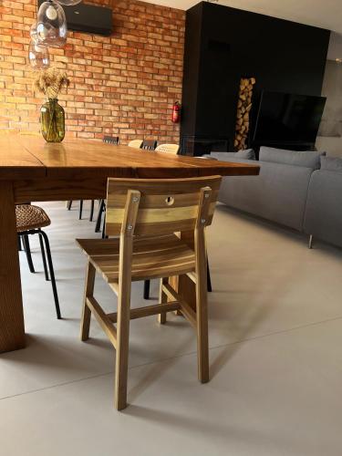 a wooden dining room table with a wooden chair at Lake House Borowe in Borowe