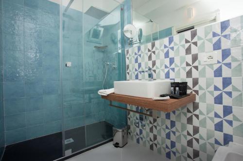 a bathroom with a sink and a shower at Aquamaris Design Suite & Spa in Paestum
