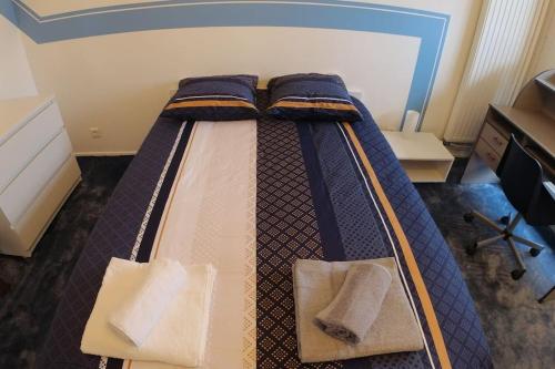 una camera da letto con un letto e due asciugamani di bnbgônes LE SKY BLUE - BALCONS - METRO FLACHET - WIFI a Villeurbanne