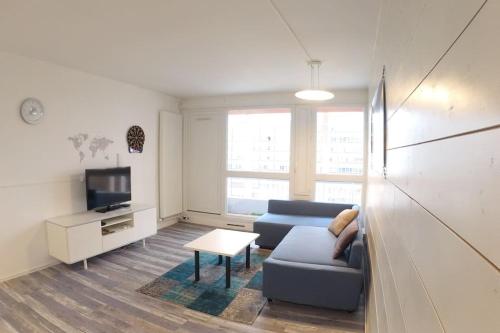 un soggiorno con divano e TV di bnbgônes LE SKY BLUE - BALCONS - METRO FLACHET - WIFI a Villeurbanne