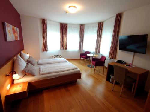 um quarto de hotel com uma cama e uma mesa com cadeiras em Bräustüble Altenmünster em Altenmünster