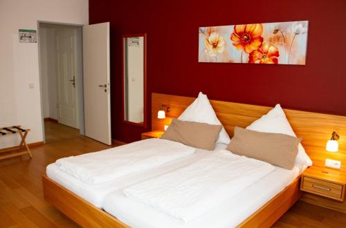 um quarto com uma grande cama branca com paredes vermelhas em Bräustüble Altenmünster em Altenmünster