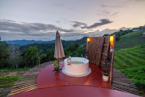 a bath tub on a table with an umbrella at เดอะเนเจอร์ ม่อนแจ่ม The nature camping monjam in Mon Jam