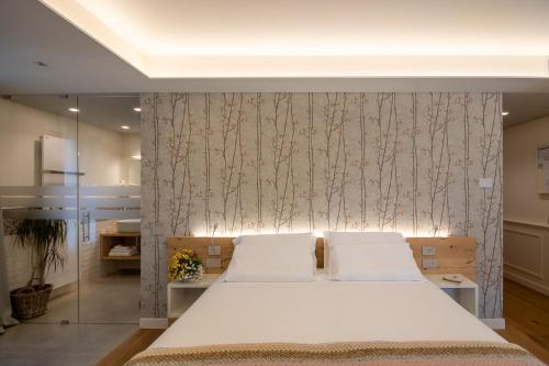 a bedroom with a large white bed with a wall at Relais Barchessa Molon in Campo di Pietra