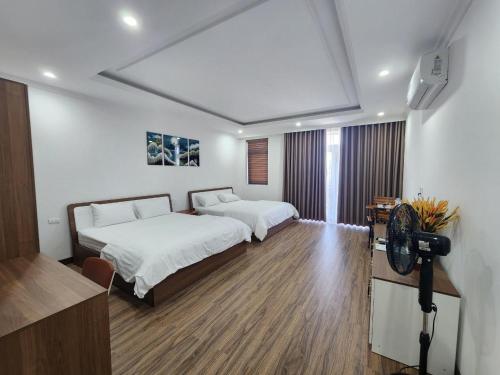 a bedroom with two beds and a television in it at Starfish house in Nghi Xuân