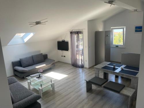 uma sala de estar com um sofá e uma mesa em Apartments villa M&M em Bibinje