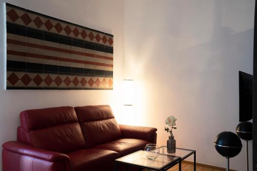 a living room with a brown leather couch and a table at Appartamento Vittoria in Bisceglie