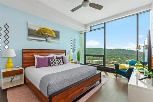 a bedroom with a bed and a large window at 'Endless Sunset Retreat' A Luxury Downtown Condo with Panoramic Mountain Views at Arras Vacation Rentals in Asheville