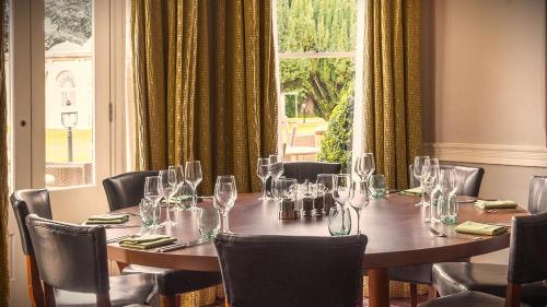 a dining room with a table with wine glasses on it at Barton Hall Hotel & Spa in Kettering