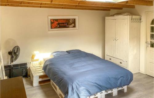 a bedroom with a bed with a blue comforter at Cozy Home In Tiendeveen With Wifi in Tiendeveen