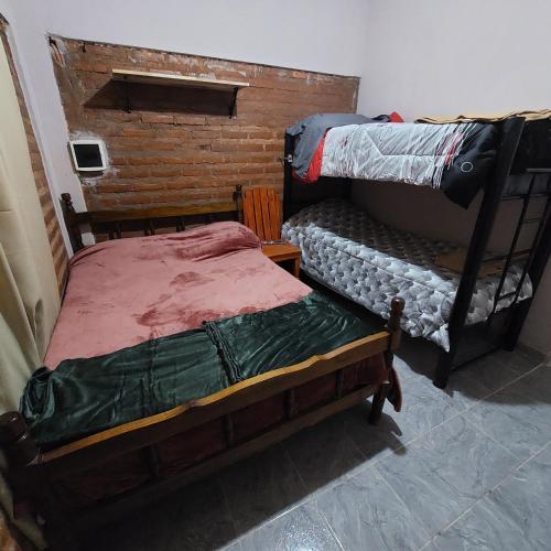 a bedroom with two bunk beds and a brick wall at El gumer in San Fernando del Valle de Catamarca