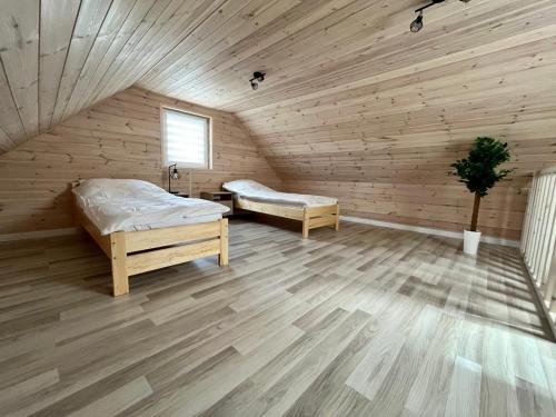 Habitación de madera con 2 camas en un ático en Przystań Tolkmicko en Tolkmicko