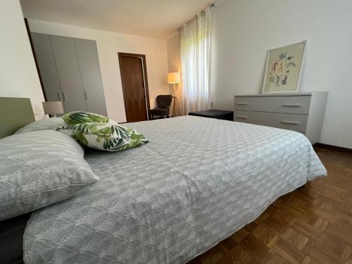 una camera da letto con un letto e un piumone bianco di Casa Parisi Lago Maggiore a Baveno