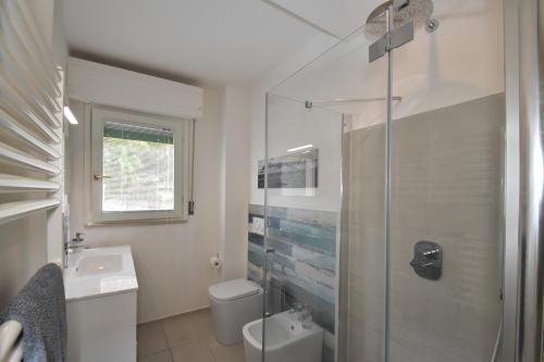 uma casa de banho com um chuveiro, um WC e um lavatório. em Rada em Marina di Campo