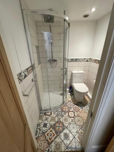 uma casa de banho com um chuveiro e um WC. em Egos em Castle Donington