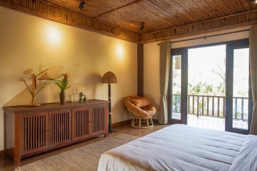 a bedroom with a large bed and a balcony at Hồ Đá Cổ Thiên Long Resort Hòa Bình in Hòa Bình