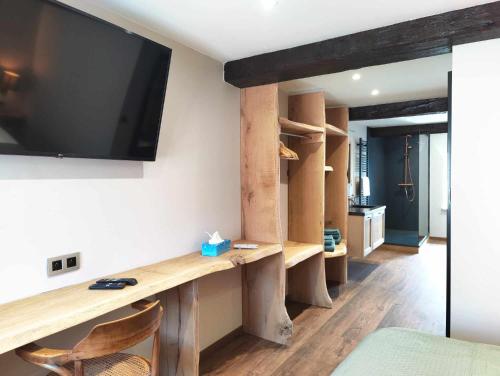 a living room with a tv and a wooden desk at Le Saint Michel in Rochefort