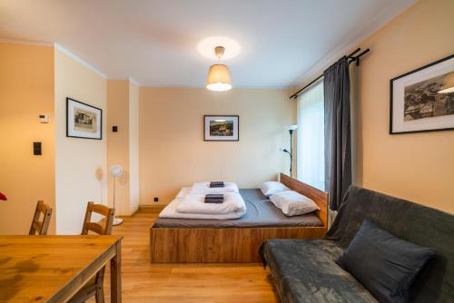 グウシツァにあるApartament - Nocna Sowaのベッドルーム(ベッド1台、ソファ付)