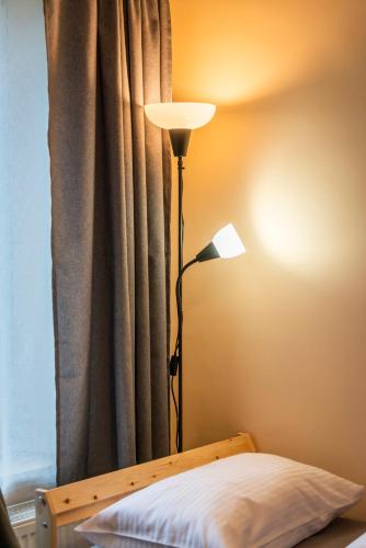 a lamp sitting next to a bed with a curtain at Apartament - Nocna Sowa in Głuszyca